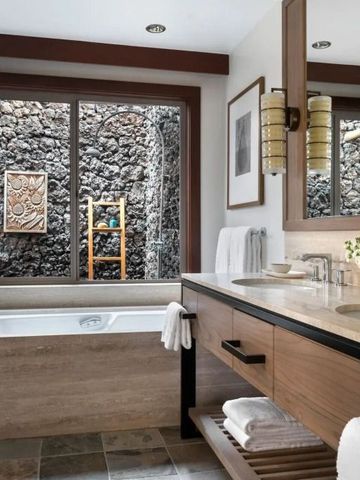 Badezimmer mit Wanne und dekorativer Steinwand im Freien