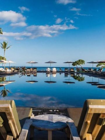 Infinity Pool mit Blick auf den Ozean und Sonnenliegen
