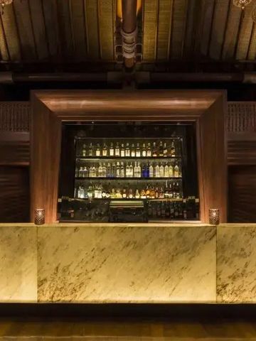 Elegante Bar mit Holzdach und beleuchteten Spirituosenregalen