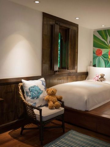 Gemütliches Kinderzimmer mit Holzmöbeln und buntem Wandbild