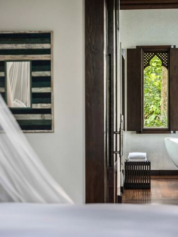 Blick von Schlafzimmer auf elegantes Badezimmer mit freistehender Badewanne