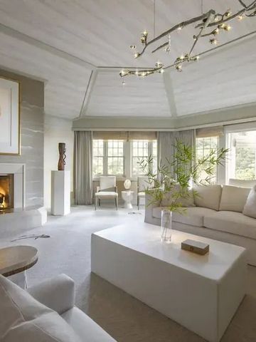 Elegantes Wohnzimmer mit Kamin und großem Sofa in neutralen Tönen