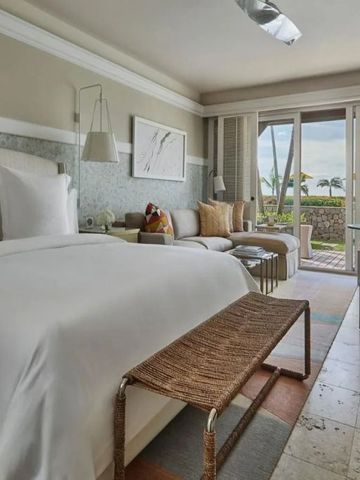 Helles Schlafzimmer im Four Seasons Resort Nevis mit direktem Zugang zum Balkon.