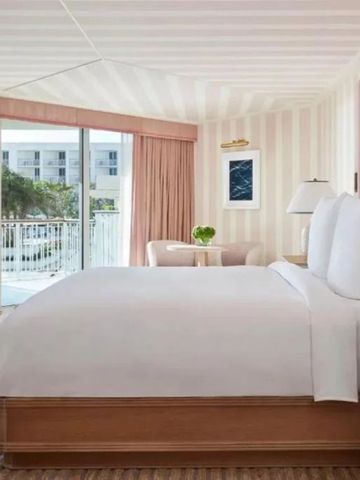 Komfortables Schlafzimmer mit modernem Design und Balkon im Four Seasons