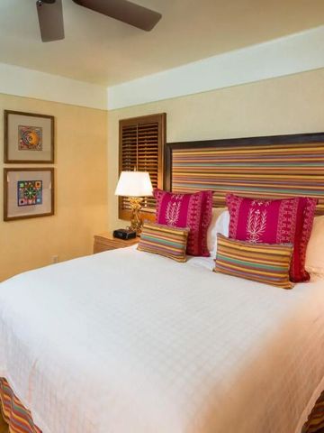 Komfortables Schlafzimmer mit stilvoller Einrichtung und bunten Kissen.