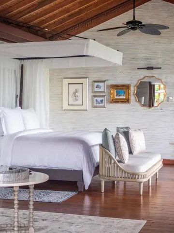 Luxuriöses Schlafzimmer mit Himmelbett und Holzdach in heller, eleganter Umgebung