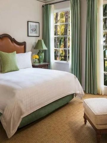 Bright hotel room with large windows and garden view