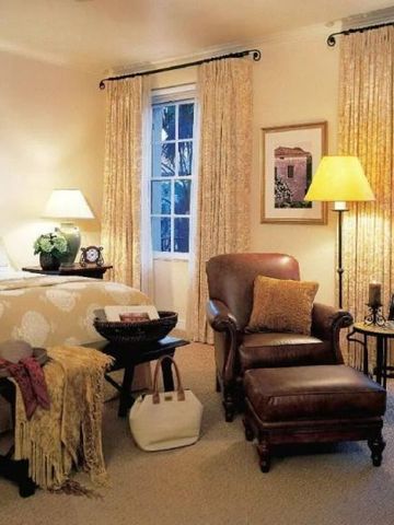 Gemütliches Schlafzimmer mit Ledersessel und eleganter Beleuchtung