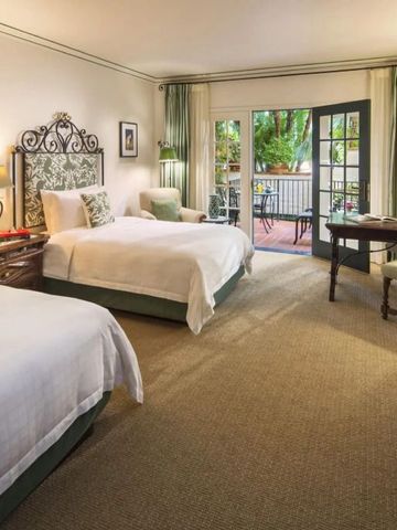 Geräumiges Doppelzimmer mit eleganter Einrichtung und Zugang zu einem Balkon mit Gartenblick