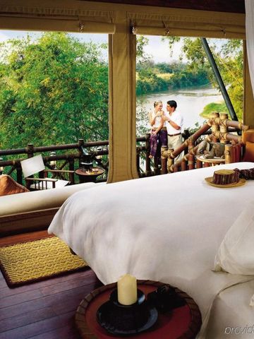 Luxuriöses Zelt mit Blick auf Fluss und dichten Wald im Four Seasons Tented Camp.