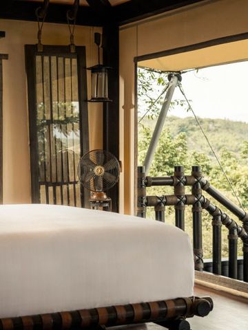 Elegantes Schlafzimmer mit Panoramablick auf die umliegende Natur im Four Seasons Tented Camp.