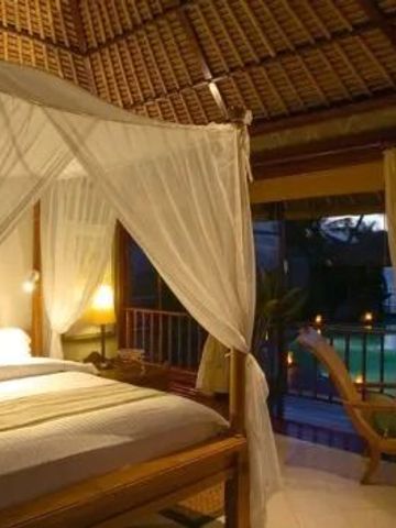 Gemütliches Schlafzimmer in Villa mit Himmelbett und Aussicht bei Abenddämmerung.