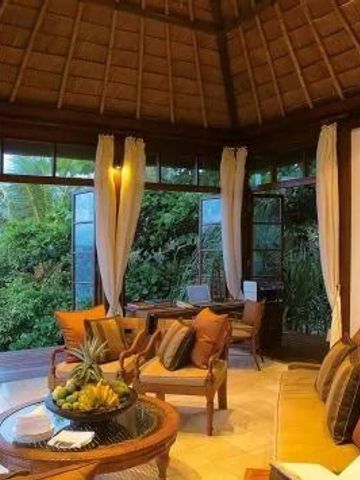 Geräumiges Wohnzimmer mit exotischem Gartenblick und komfortabler Einrichtung.