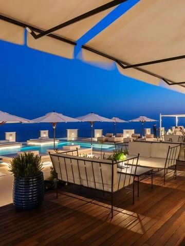 Luxuriöse Terrasse bei Nacht mit Blick aufs Meer und Pool
