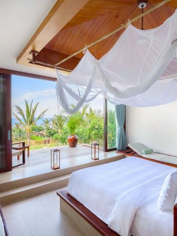Helles Schlafzimmer mit Moskitonetz und Terrasse mit Meerblick