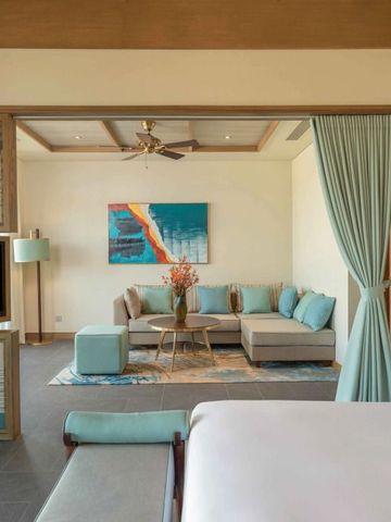 Luxuriöse Sitzecke in Suite mit kunstvoller Wanddekoration im Fusion Resort & Villas Da Nang