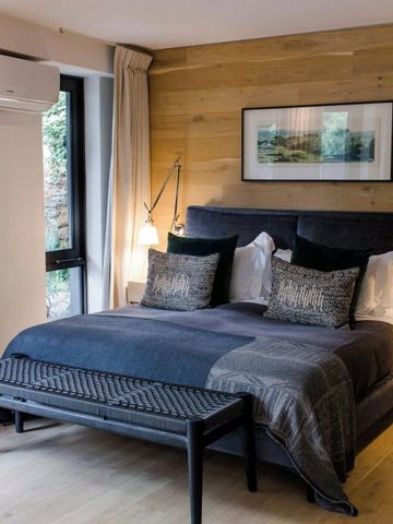 Elegantes Schlafzimmer mit Holzverkleidung und großen Fenstern.