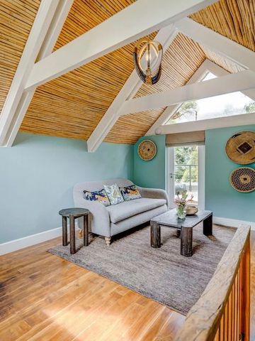 Heller Dachboden mit Sofa und Tisch, Holzboden und Dachschrägen