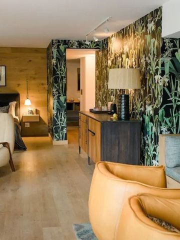 Elegantes Zimmer mit Pflanzenmotiv-Tapete und gemütlicher Sitzecke