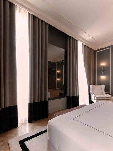 Stilvolles Hotelzimmer mit großen Vorhängen und luxuriösem Doppelbett