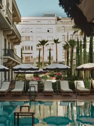 Außenpoolbereich mit Sonnenliegen und Sonnenschirmen