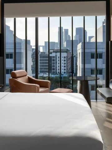 Luxuriöses Hotelzimmer mit Panoramafenster und Stadtblick.