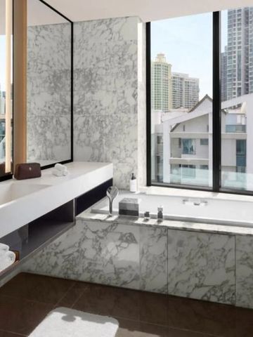 Luxuriöses Badezimmer mit Marmorverkleidung und Stadtblick