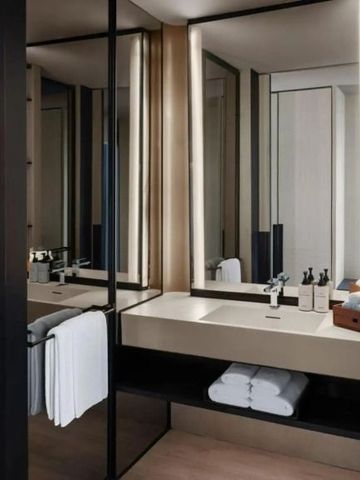 Elegantes modernes Badezimmer mit großer Spiegelwand, Waschbecken und Handtuchablage