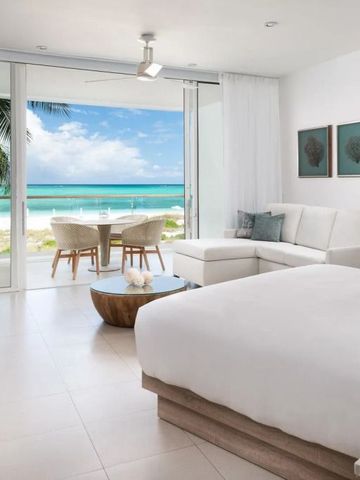 Offenes Zimmer mit Blick auf Strand und Meer durch große Fenster