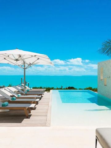 Sonnenliegen an einem Infinity-Pool mit Blick auf das türkisblaue Meer