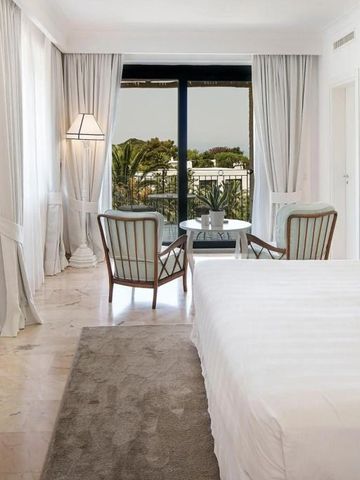 Helles Schlafzimmer mit Marmorboden und Balkonblick auf Palmen