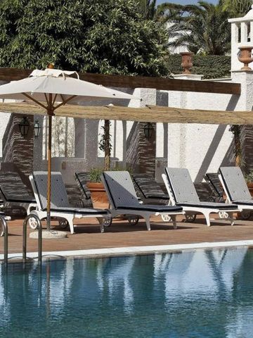 Sonnenliegen am Pool mit weißer architektonischer Kulisse