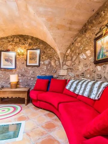Gemütlicher Raum mit rotem Sofa und Natursteinmauern in Can Alomar Mallorca