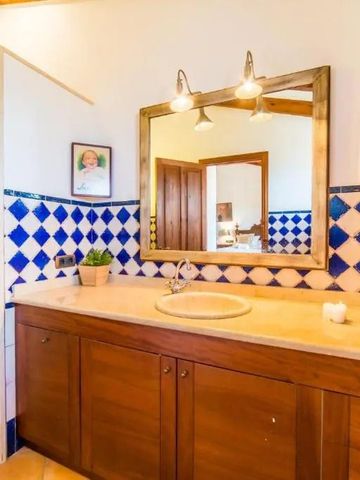 Bad mit Holzschränken und blauen Fliesen an der Wand