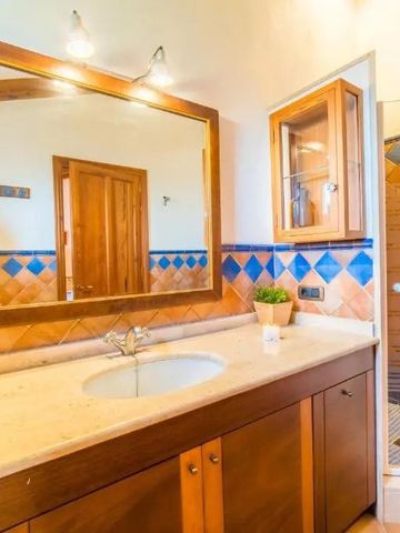 Geräumiges Bad mit großer Spiegelwand und dekorativen Fliesen