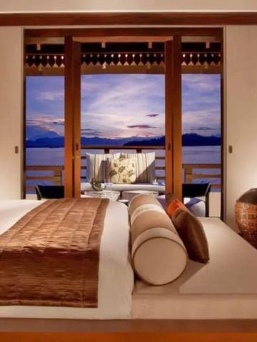 Romantisches Schlafzimmer mit großem Fenster und Meerblick