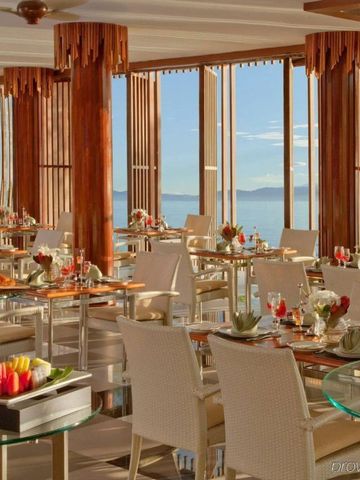 Elegantes Restaurant mit Holzelementen und Panoramablick aufs Meer