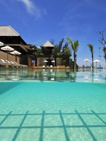 Kristallklarer Infinity-Pool am Gaya Island Resort mit Palmen und Himmel