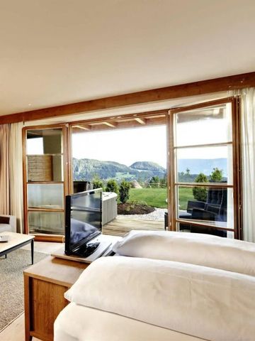 Geräumiges Zimmer mit bodentiefen Fenstern und Bergblick.