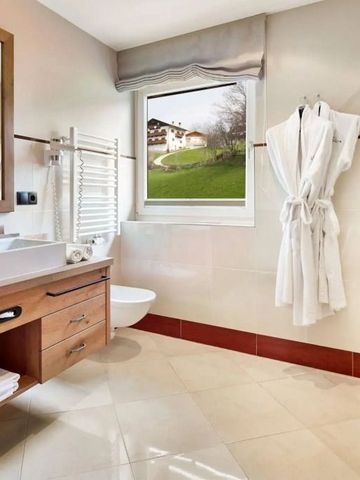 Helles Badezimmer mit großem Spiegel und Blick ins Grüne