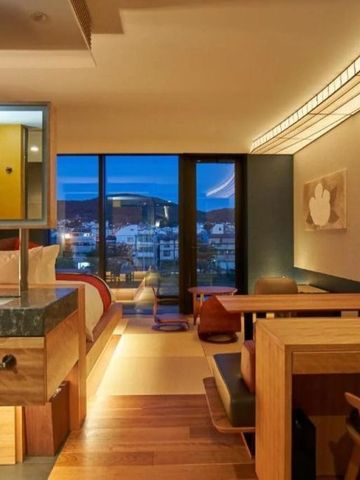 Luxuriöses Zimmer bei Nacht mit Sitzecke und Panoramafenster