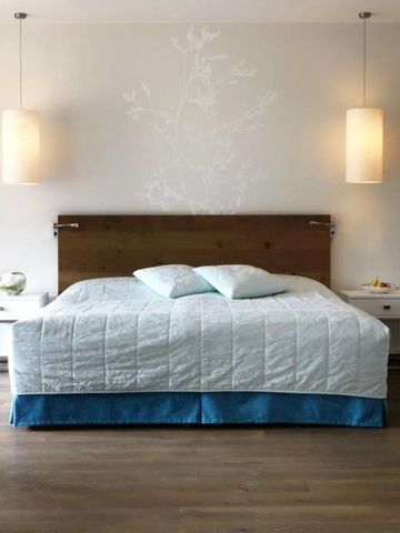 Modernes Hotelzimmer mit stilvollem Bett und sanfter Beleuchtung