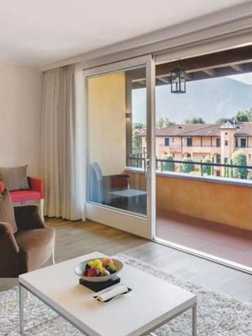 Hotelzimmer mit großem Fenster und Blick auf den Balkon und Berge