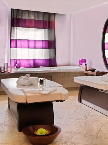 Entspannender Behandlungsraum mit Massageliegen und lila Akzenten