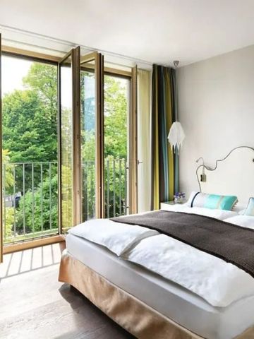 Lichtdurchflutetes Schlafzimmer mit bodentiefen Fenstern und sanften Farben