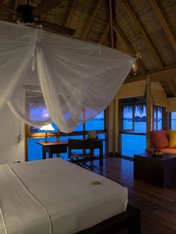 Gemütliches Schlafzimmer mit Sitzecke und Meerblick in der Abenddämmerung