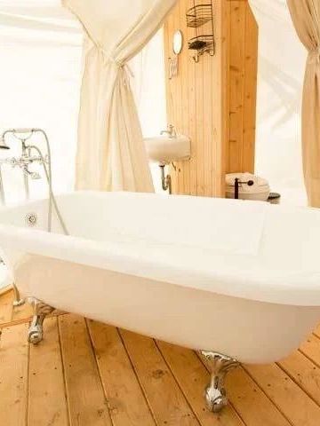 Freistehende Badewanne in luxuriösem Zelt mit Holzfußboden