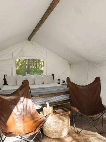 Gemütliches Zelt mit Doppelbett und Sitzgelegenheiten im Safaristil