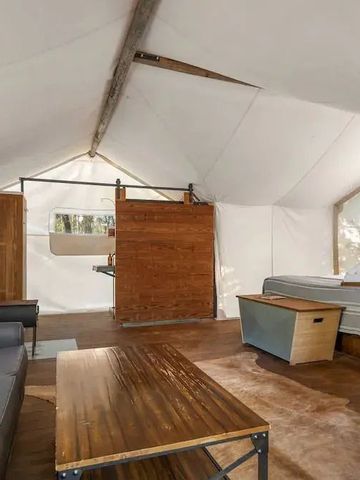 Großzügiges Zeltzimmer mit Holz- und Ledermöbeln