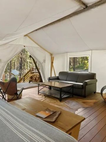 Innenansicht eines luxuriösen Zeltes mit Sofa und Holztisch